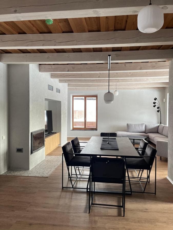 Valgomojo stalas su kėdėmis jaukioje bendroje erdvėje