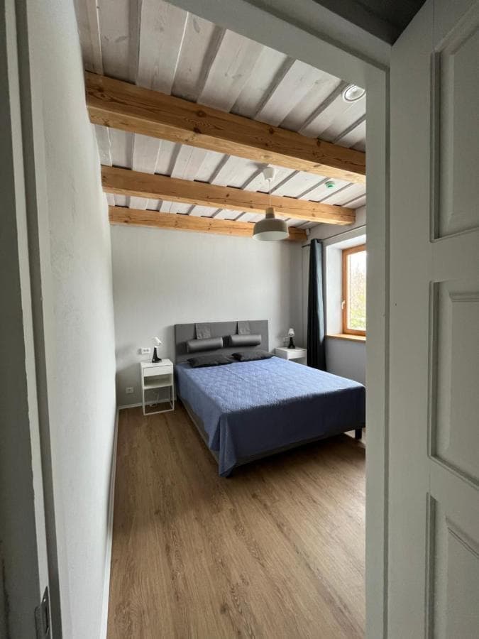 Šviesus miegamasis su dvigule lova ir lauko vaizdu pro langą