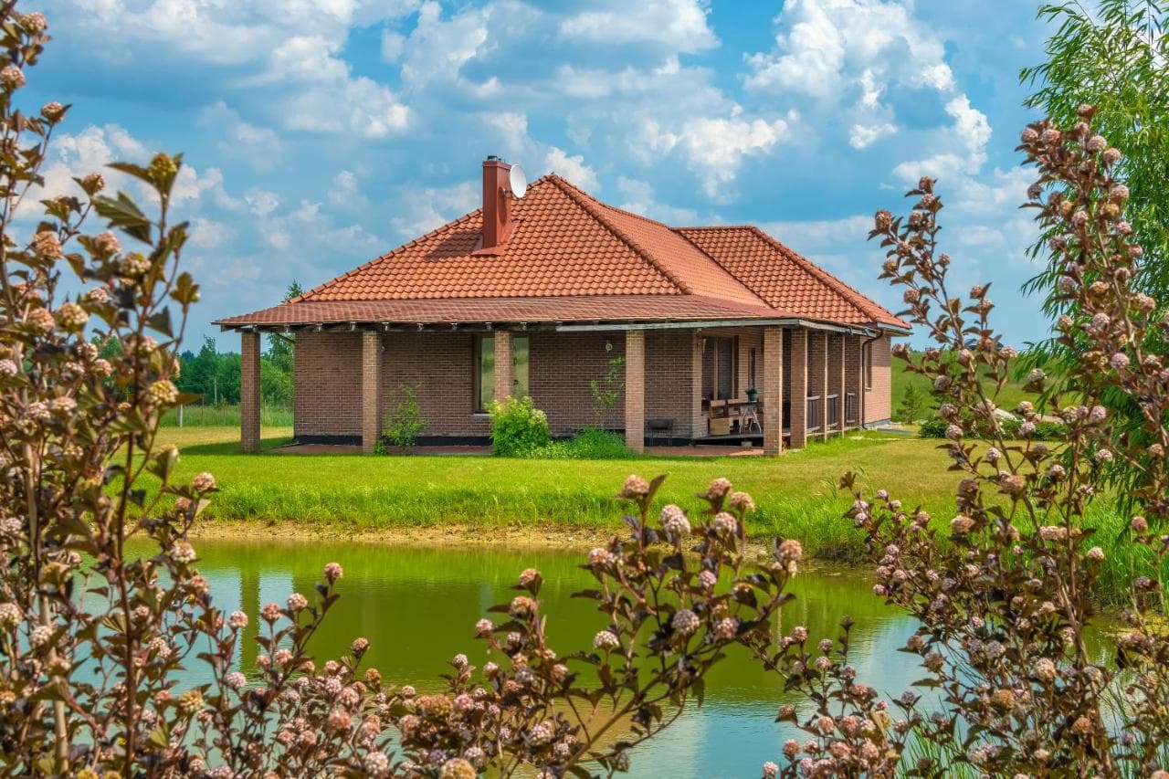 Gėlės prie svečių namo ir žalios pievos