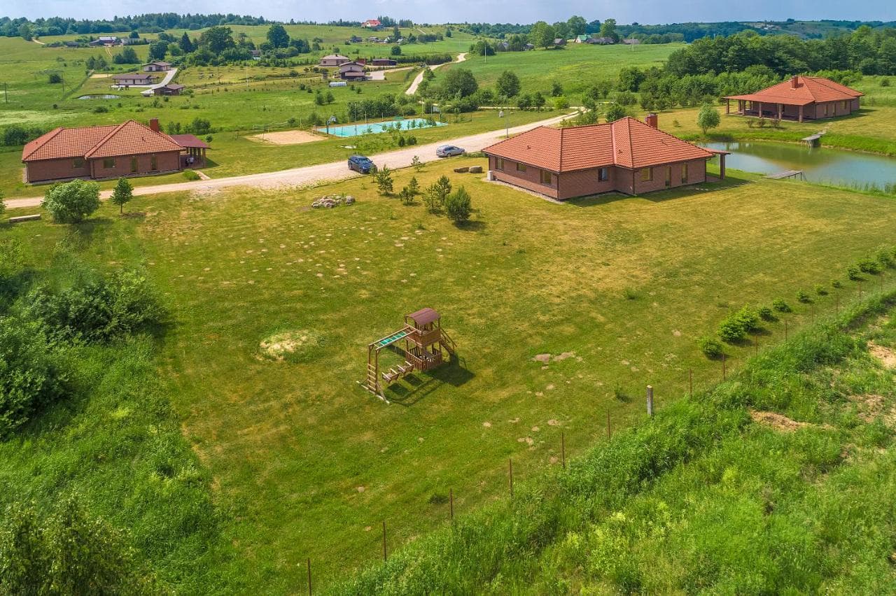 Dronu fiksuotas vaizdas į svečių namus aplinkinio kraštovaizdžio fone