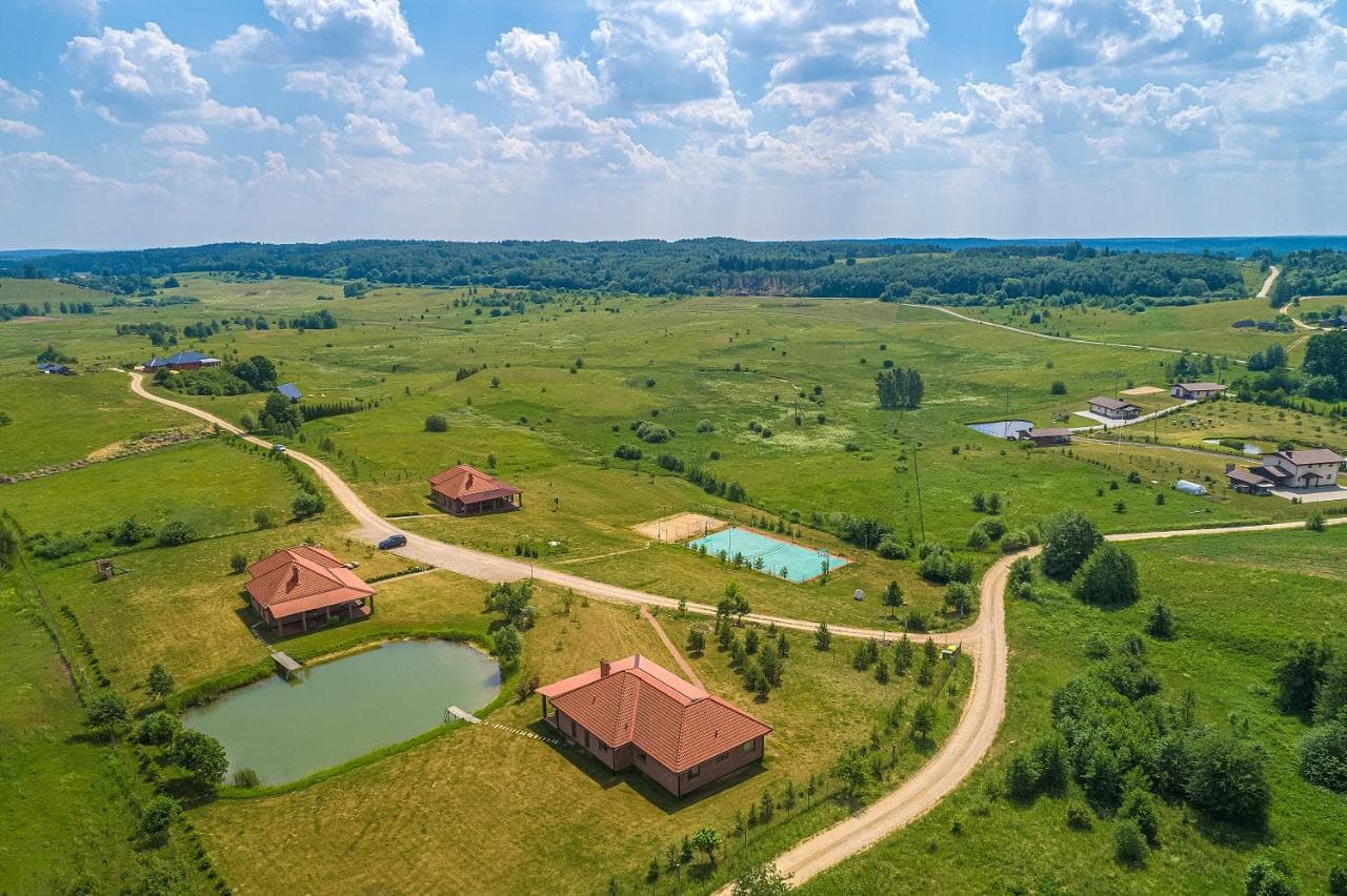 Kaimo kraštovaizdis su ežeru tolumoje ir svečių namais