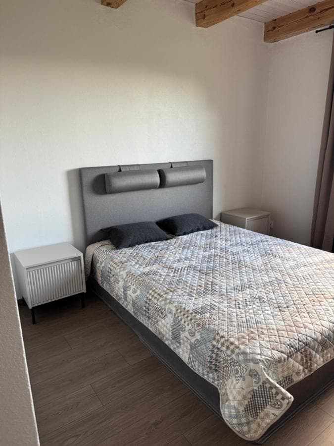 Šviesus miegamasis su dvigule lova ir lauko vaizdu pro langą