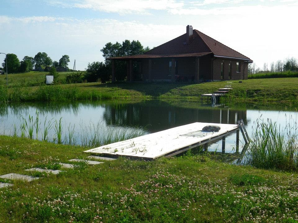 Svečių namas prie tvenkinio su mediniu liepteliu