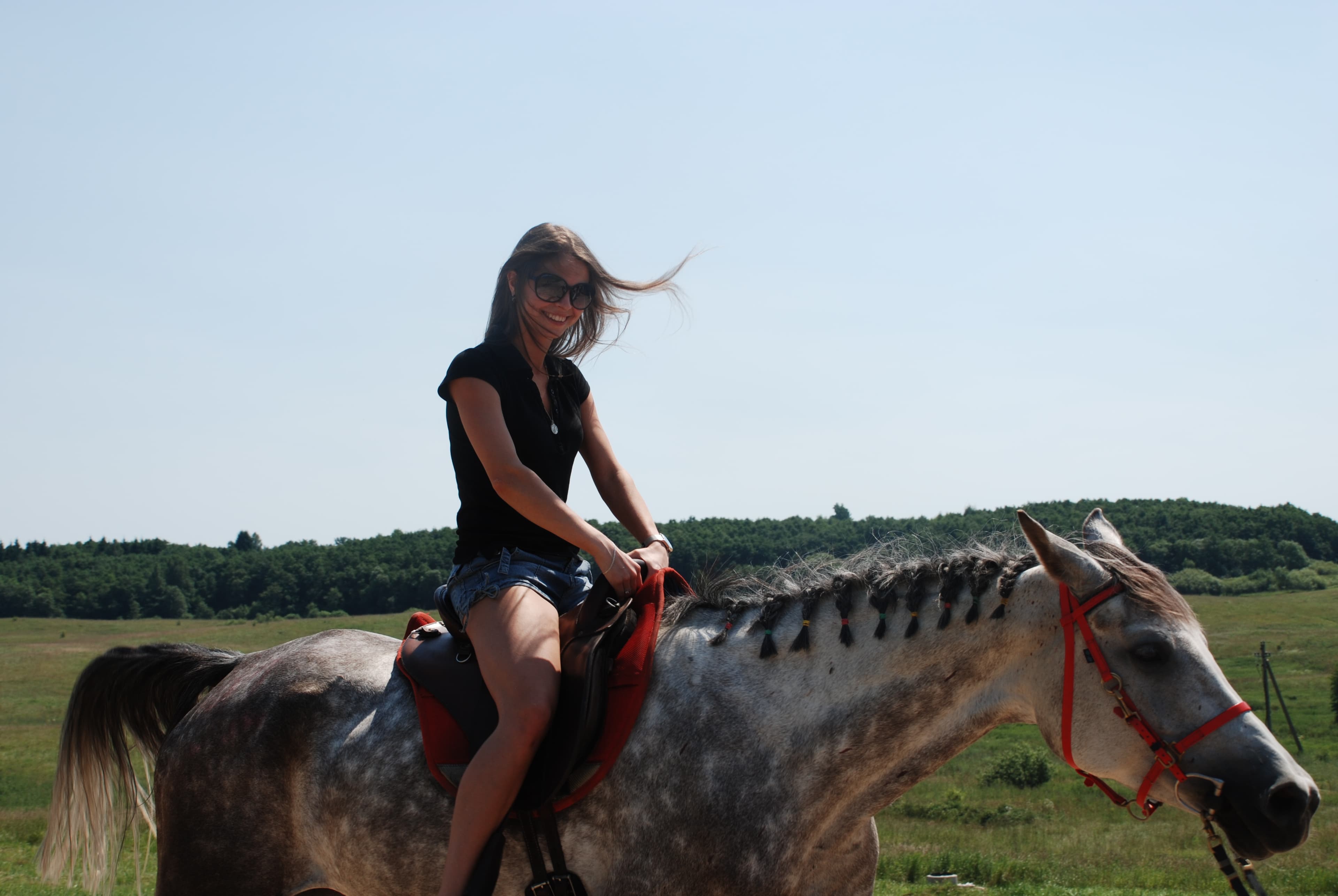Jauna moteris joja ant žirgo laukų platybėse